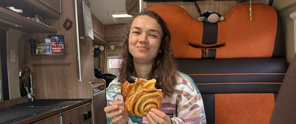 Sassi isst Franzbrötchen im Camper